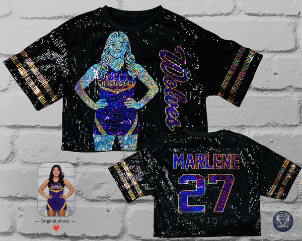 Black sequin jersey with front view of a silver, purple and gold holographic bling portrait of a cheerleader with custom text in cursive. Back shirt view has custom text and number in silver, gold and purple bling. Gold sleeve stripes. All displayed on a white brick wall.