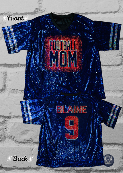 A blue sequined football jersey shown from both front and back on a white brick background. The front features a red and silver bling 'FOOTBALL MOM' graphic, and the back shows 'BLAINE' and the number '9' in red with silver outlines.