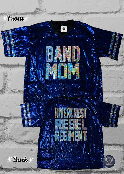 A blue sequined v-neck jersey shown from both the front and back. The front features the text 'BAND MOM' in silver holographic spangles, and the back features 'RIVERCREST REBEL REGIMENT' in silver holographic spangles with silver sleeve stripes.