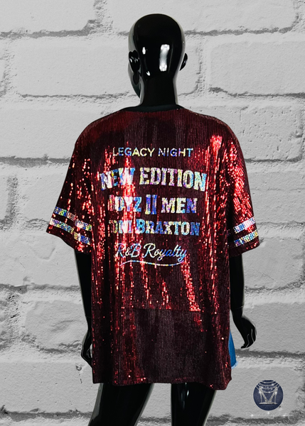 Back view of a Burgundy sequined side slit top with holographic silver spangle bling text. The shirt has short sleeves with silver holographic stripes. The shirt is displayed on a black mannequin.