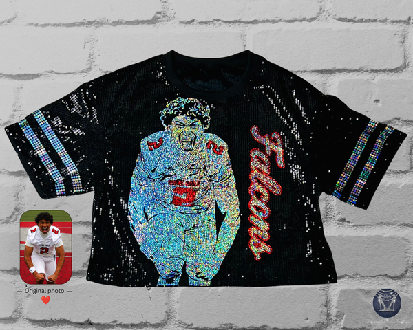 Black sequin jersey with front view of a silver and red holographic bling portrait of a football player with custom text in cursive. Silver sleeve stripes. All displayed on a white brick wall.