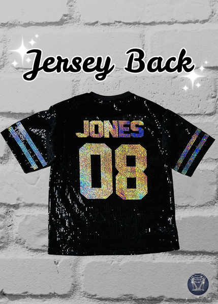 Black custom football-style sequin jersey shown from the front back with  custom text and numbers and striped bling silver sleeve accents, displayed on a black mannequin against a white brick wall.